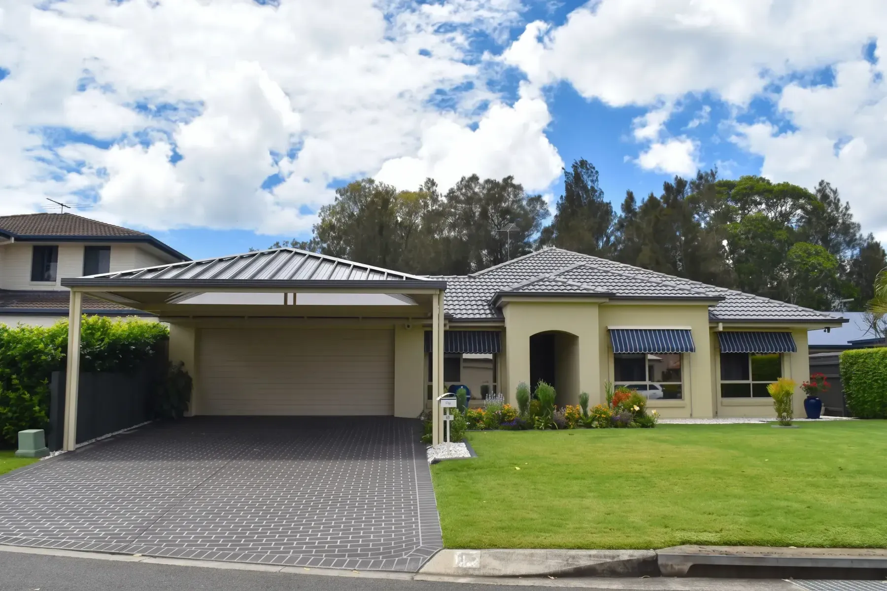 Gable carport over a paved driveway on a suburban street
