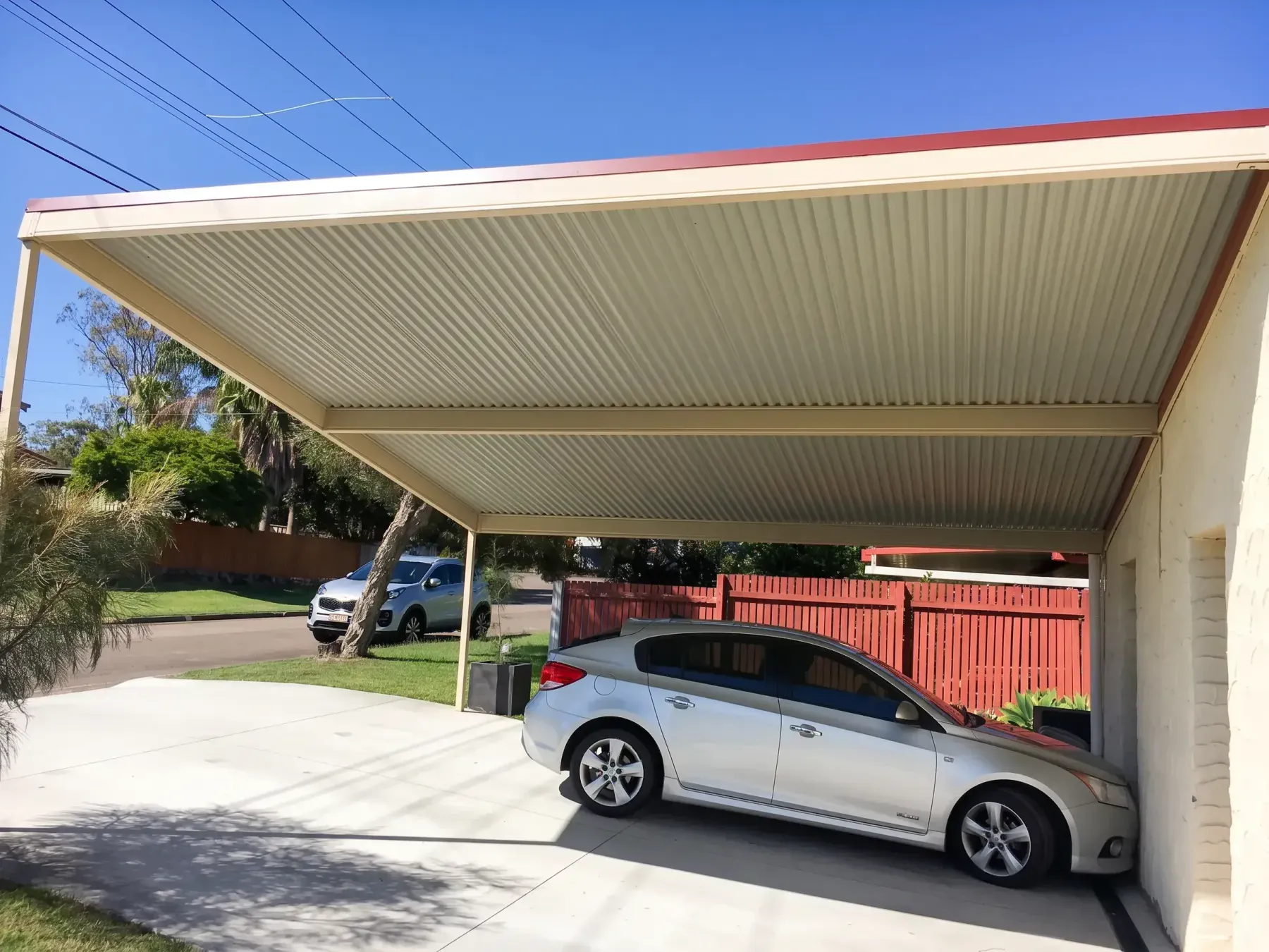Skillion carport over a silver car and concrete driveway