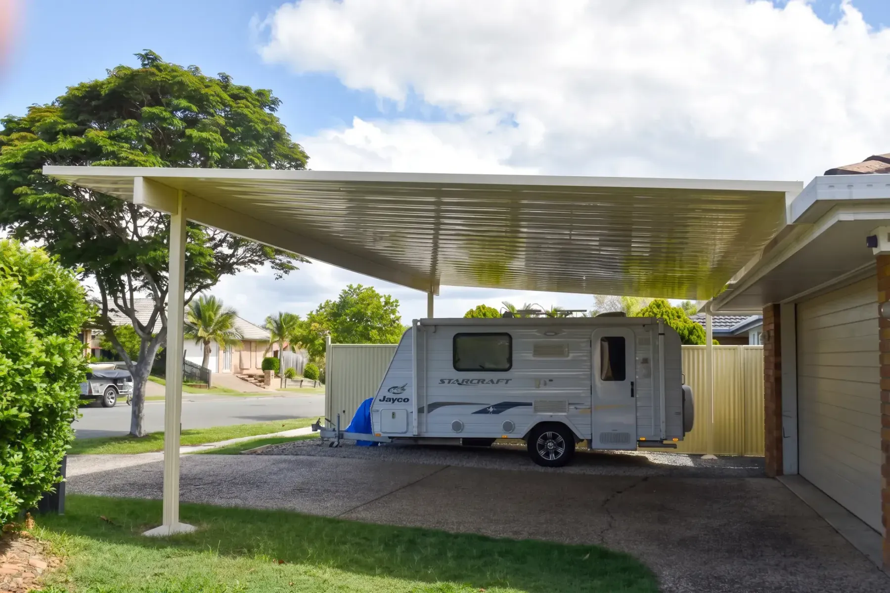 High-clearance carport over a caravan beside a home