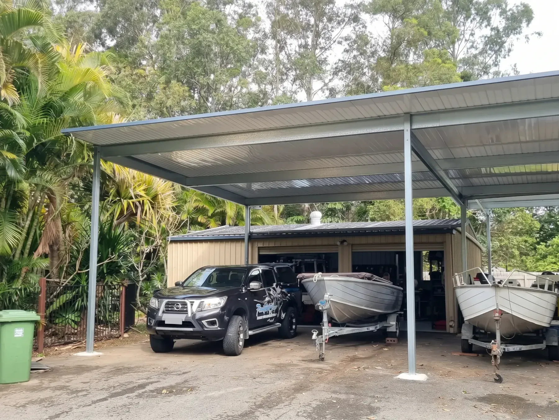 Carport over a ute and two boats on trailers