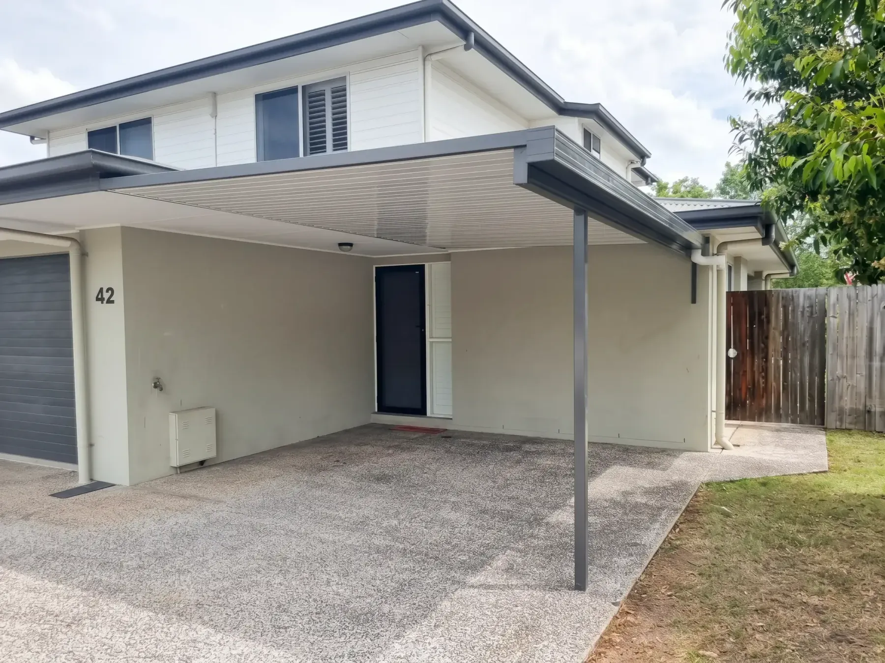 Carport beside a two-storey townhouse