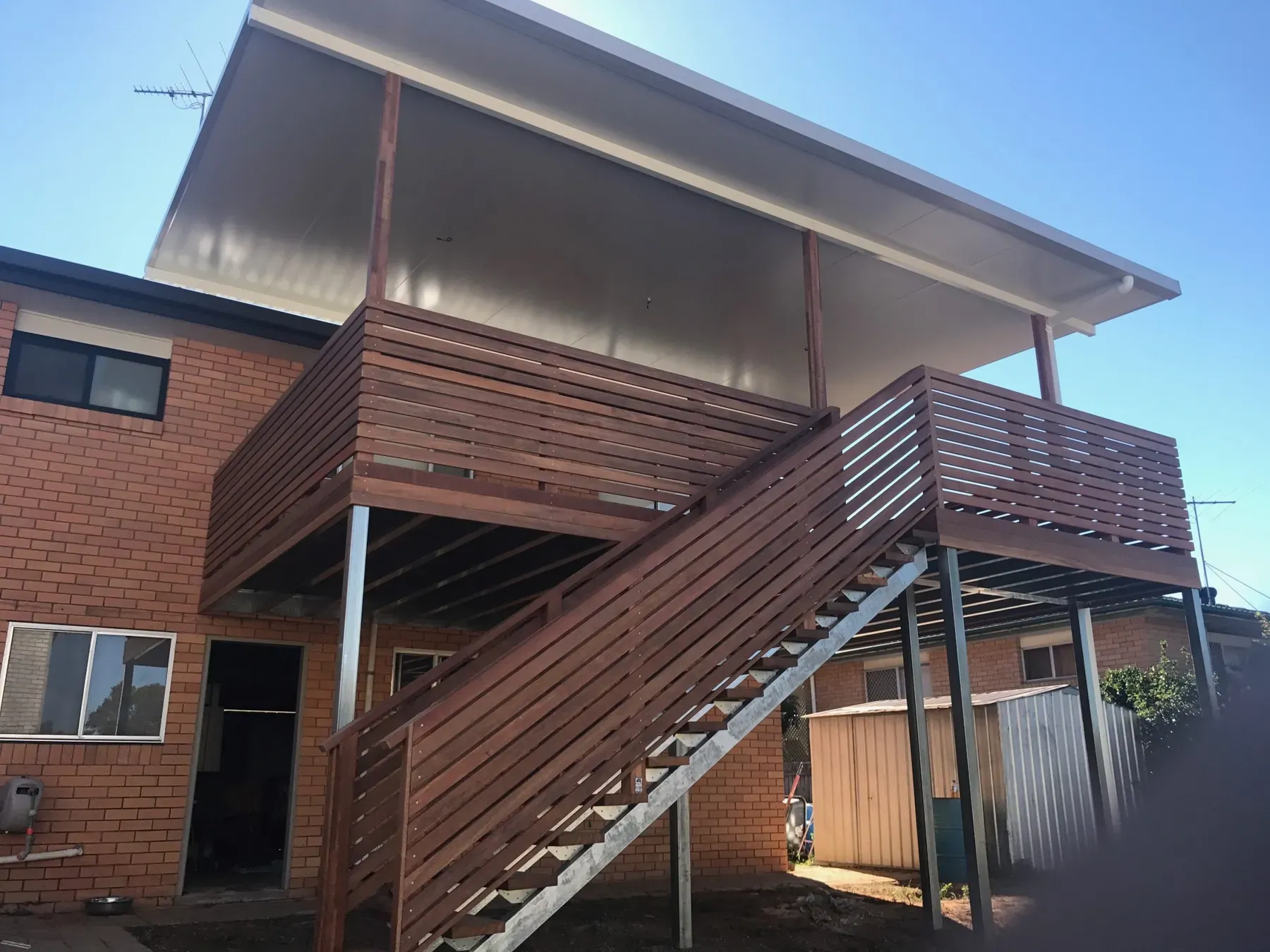 Flyover roof over an elevated deck with timber stairs