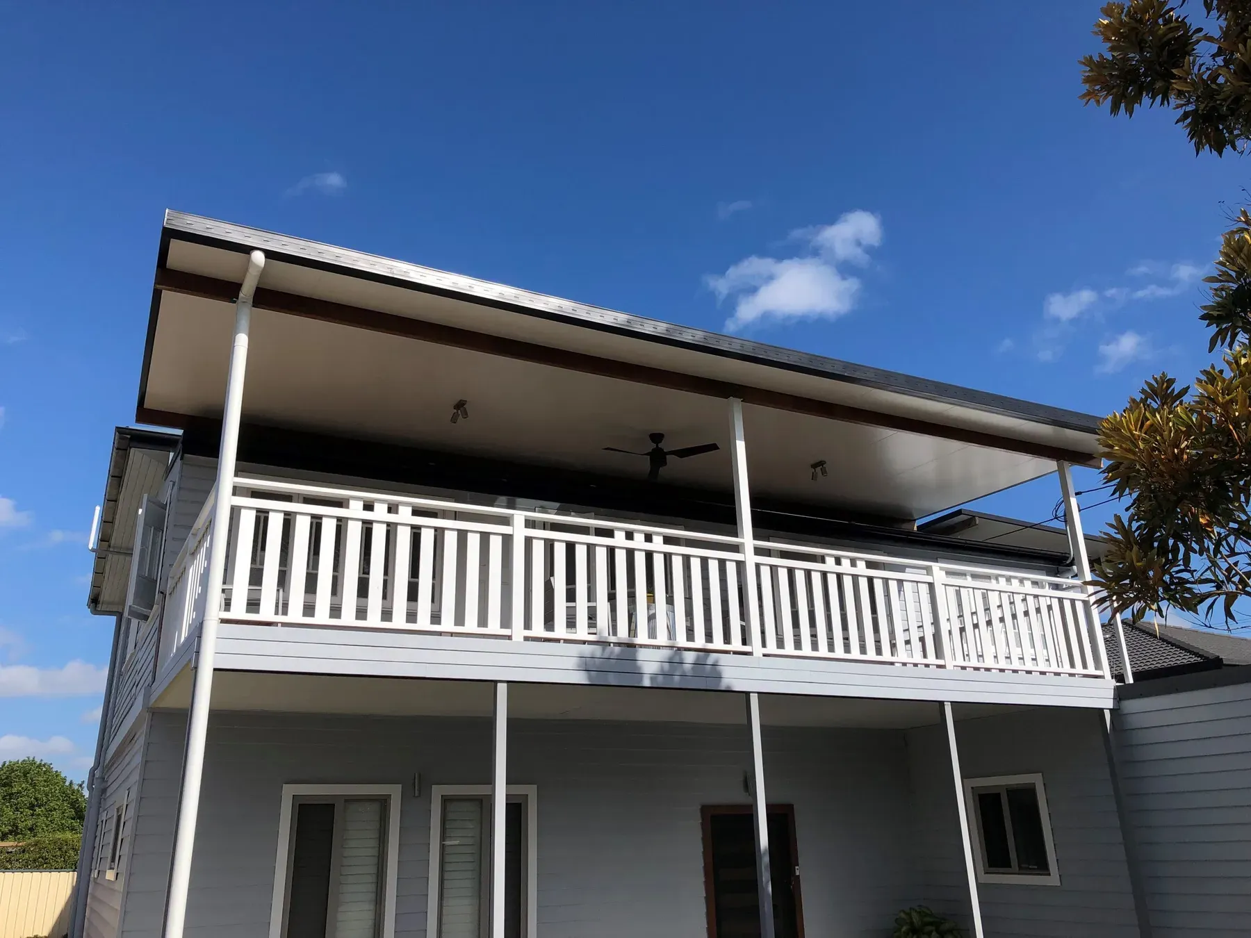 Two-storey verandah roof over a white balustrade