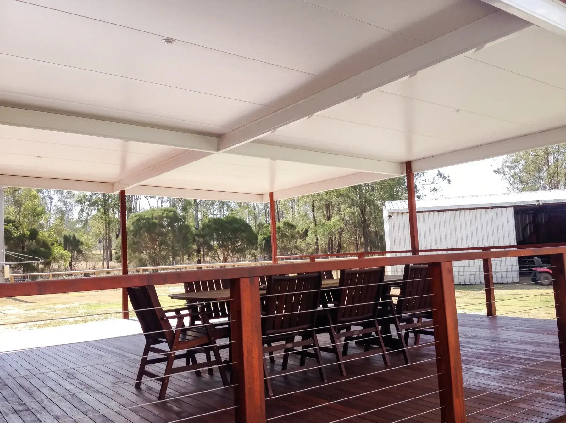 Timber deck with a dining table under a patio roof