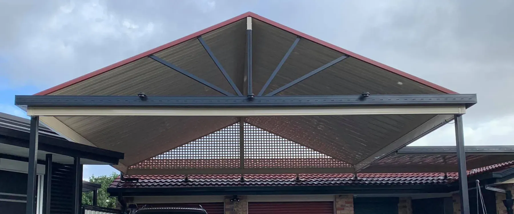 Gable carport with an exposed truss, seen from the street