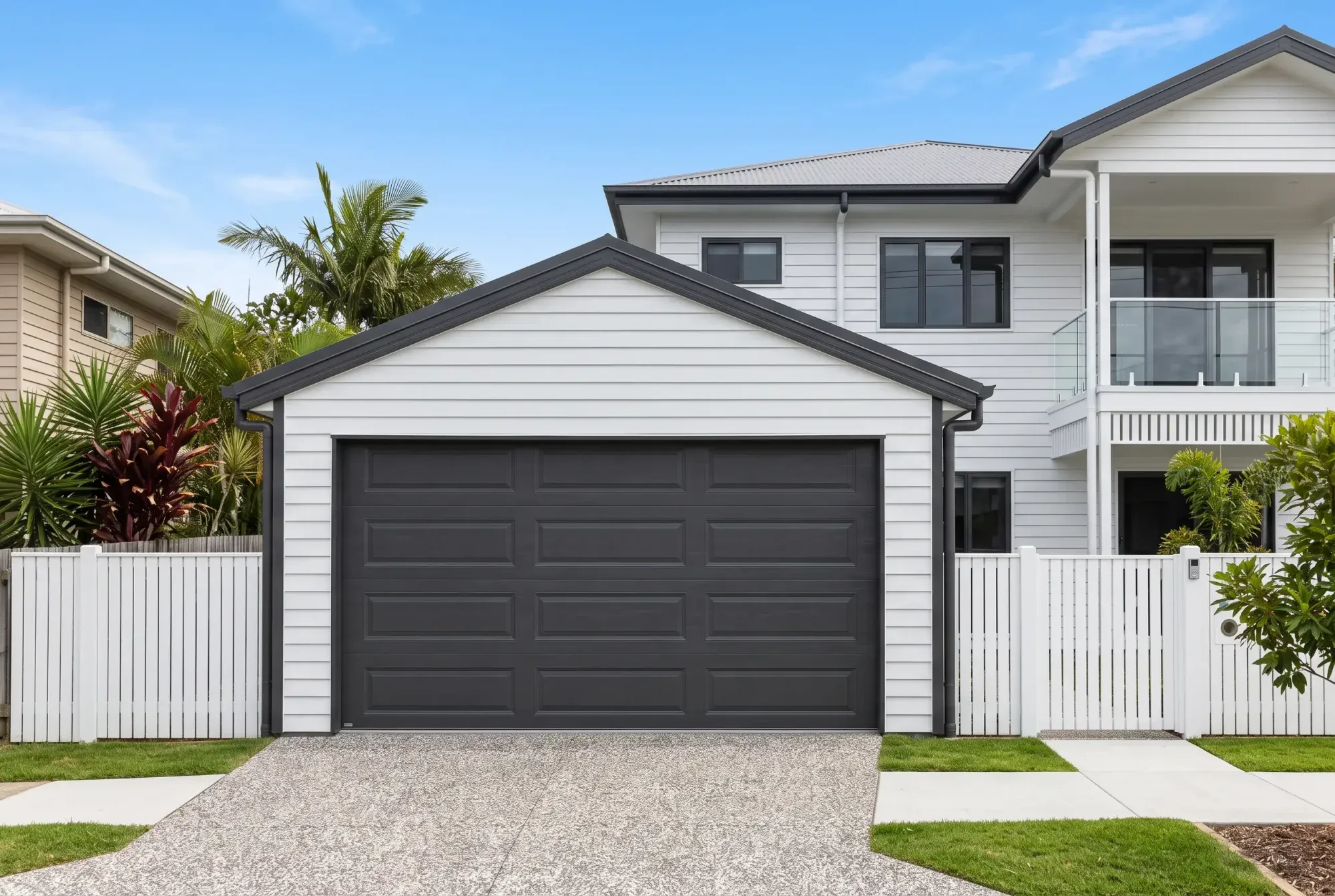 Enclosed gable garage with weatherboard walls and a dark panel door