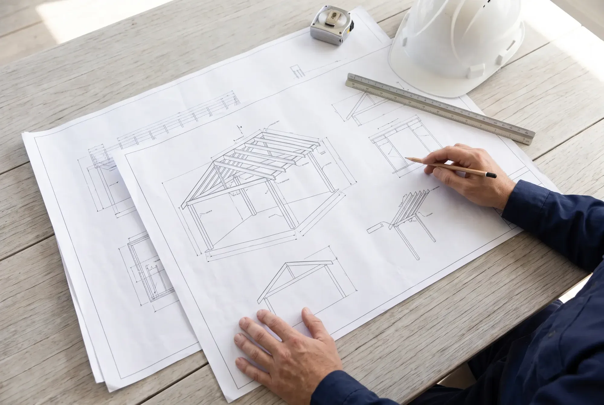 Engineering drawings for a patio on a table with a scale ruler and a tape measure