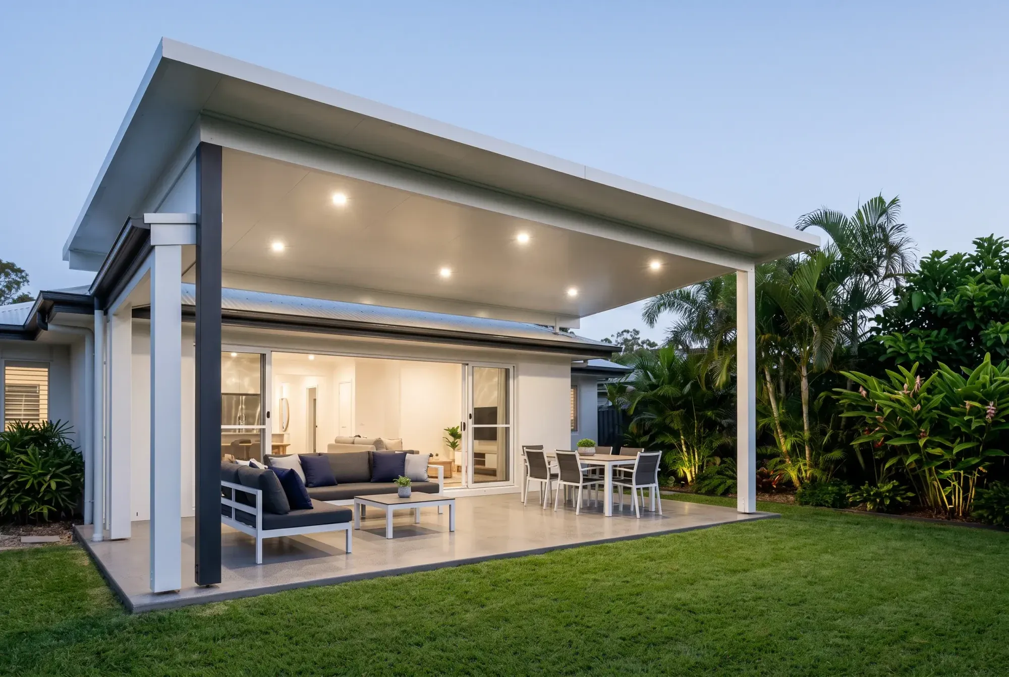 Insulated patio at dusk with its downlights on over an outdoor lounge