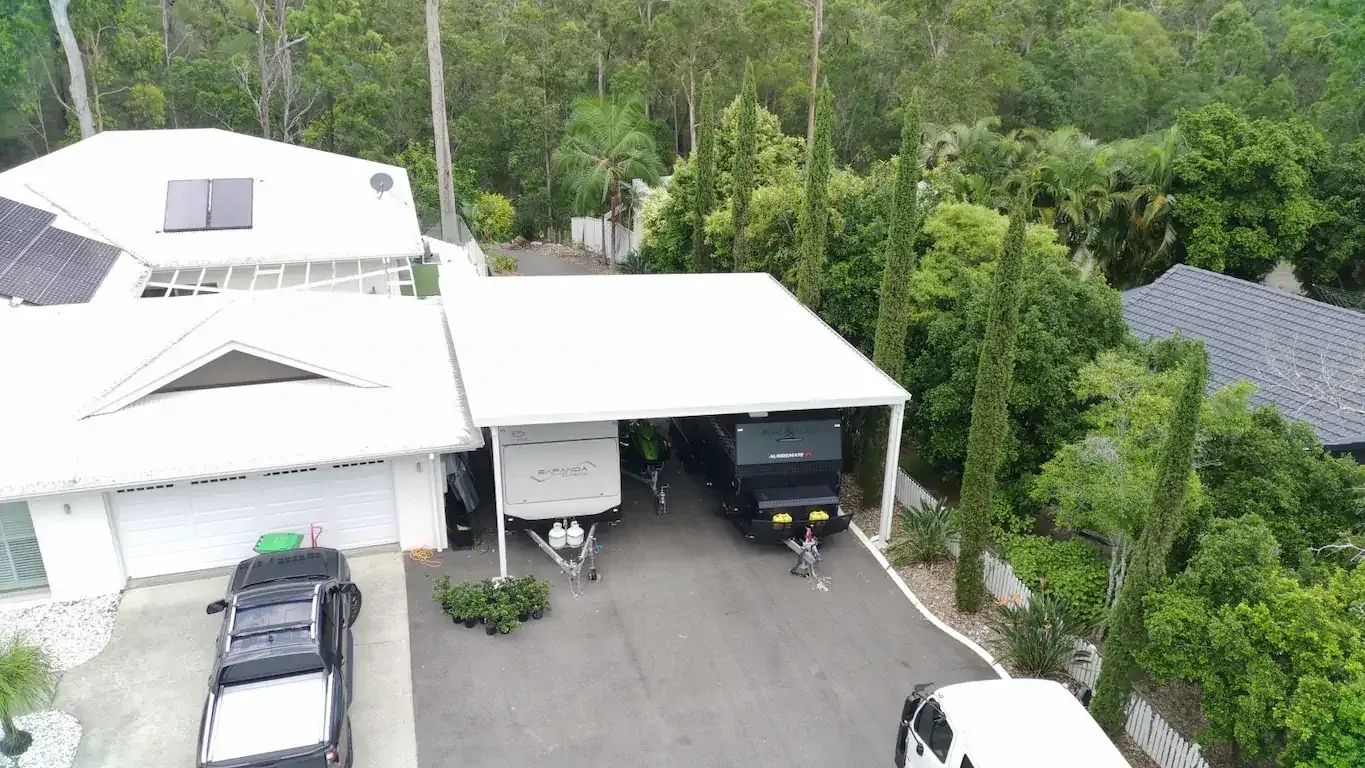 Completed double gable carport beside a brick home
