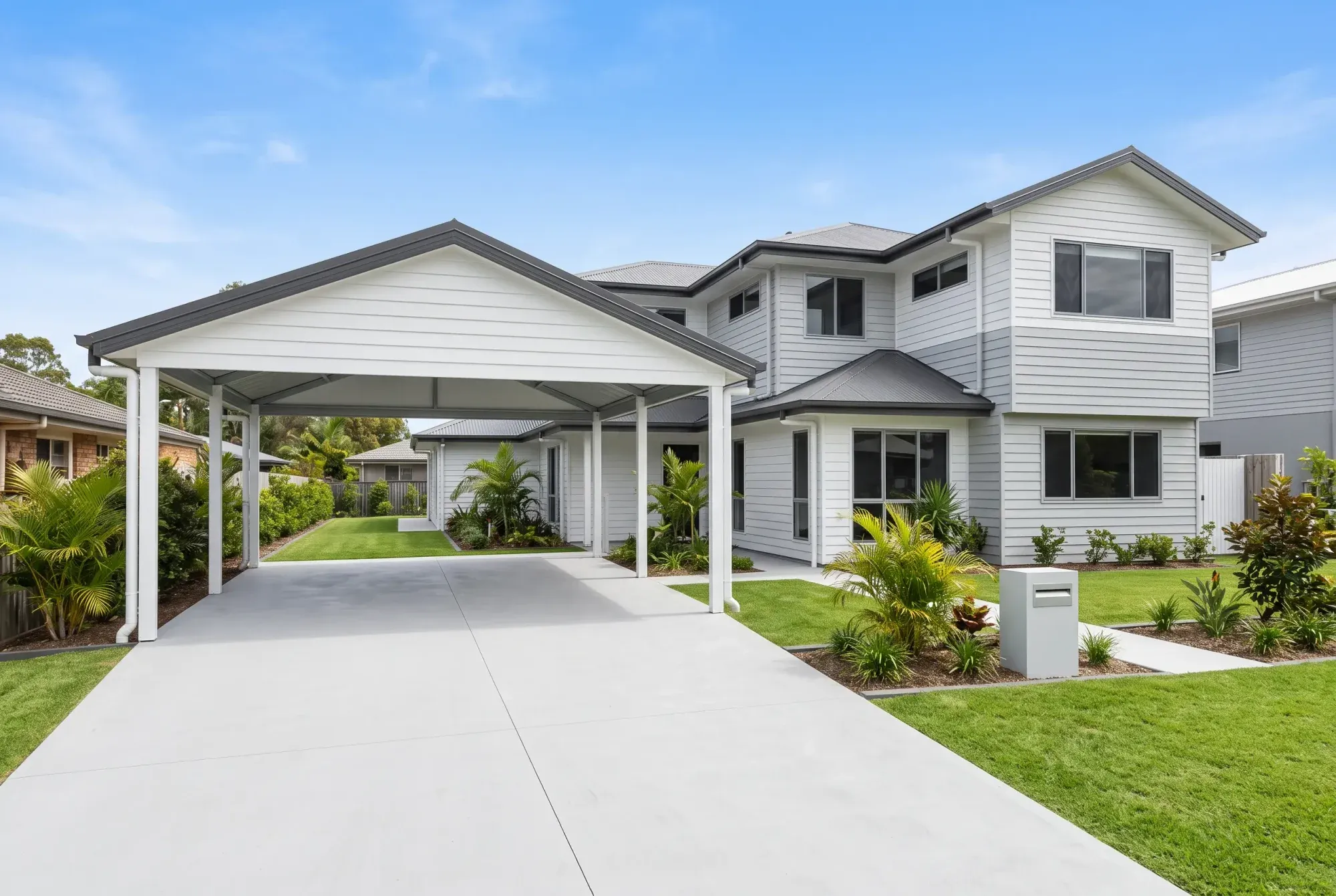 Double gable carport with clad gable ends over a long driveway
