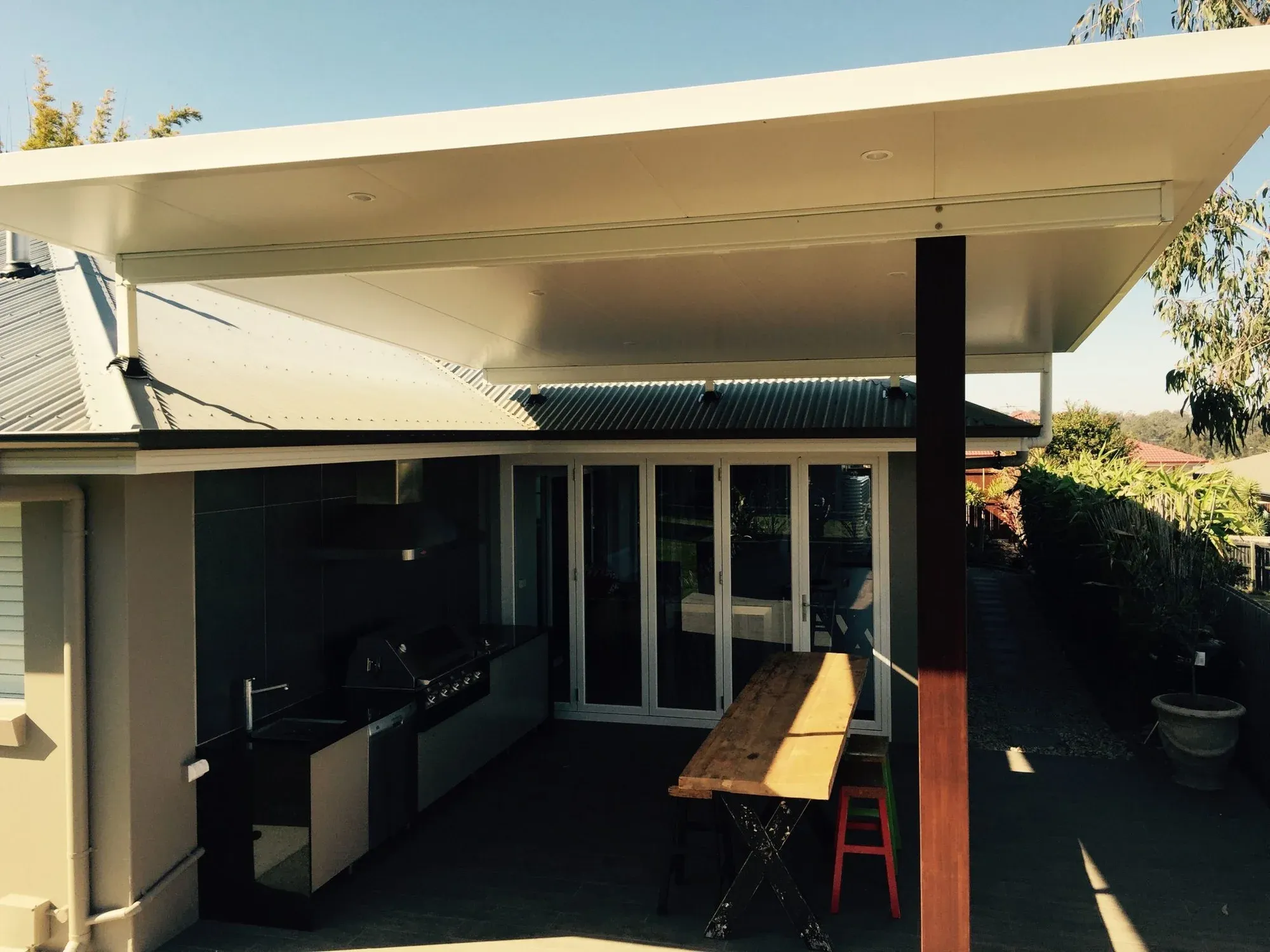 Flyover patio roof raised above an existing roofline
