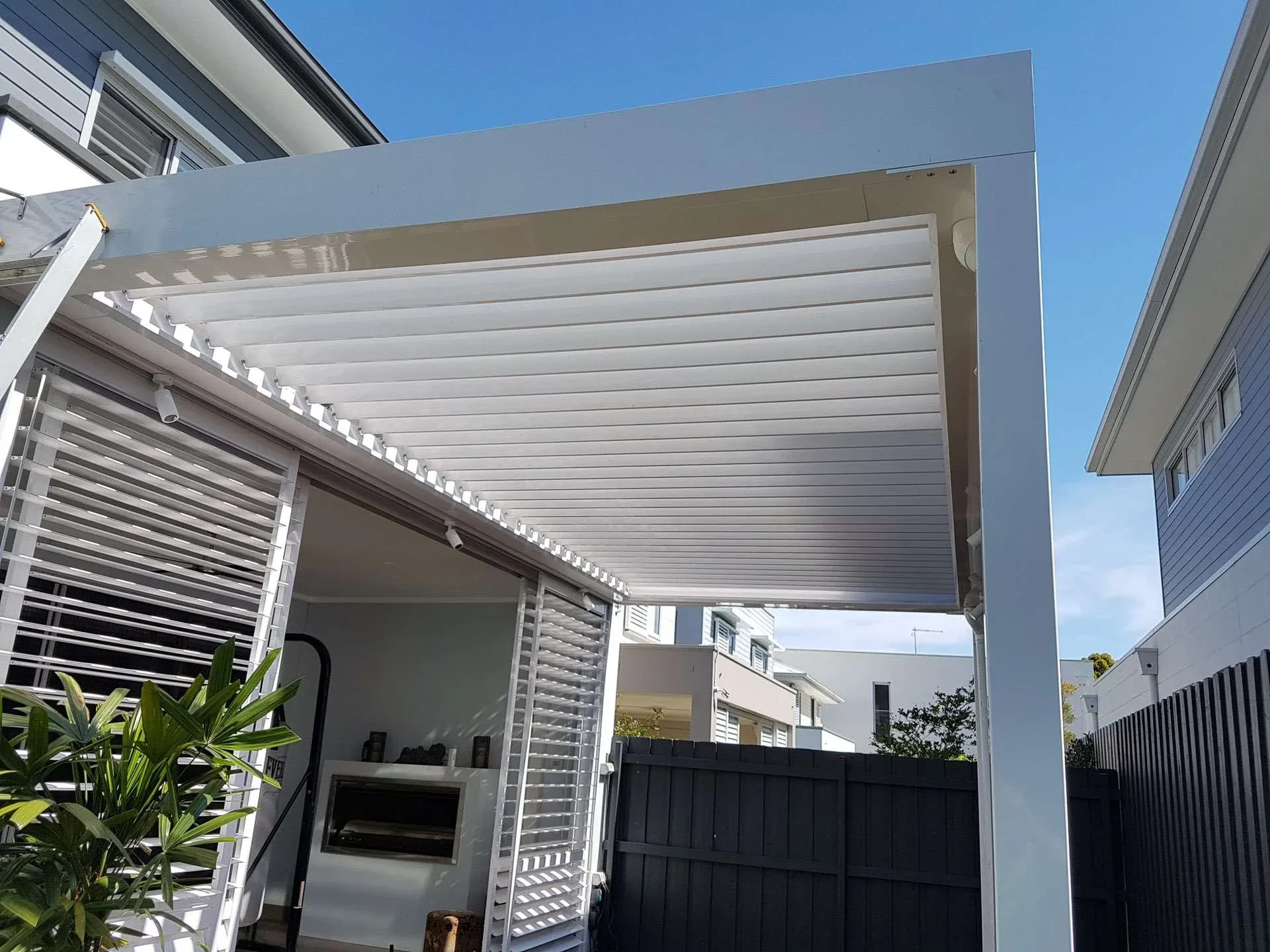 White louvred roof patio over an outdoor lounge setting